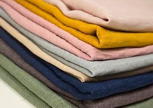 A stack of neatly folded multi color garments on top of each other. 