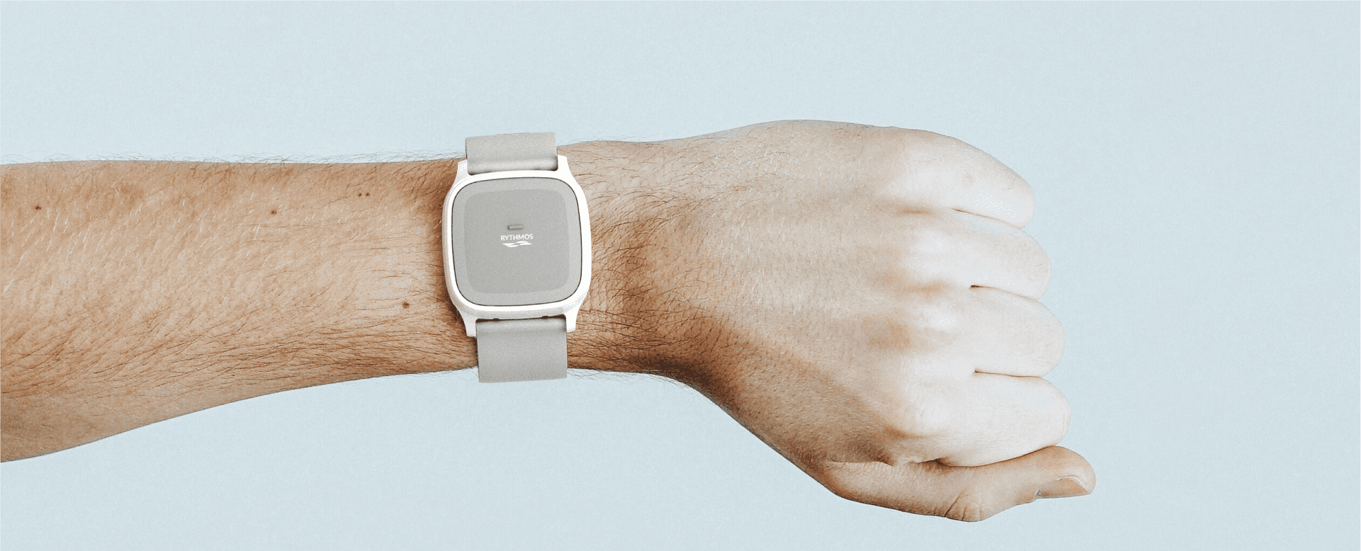 Small wearable device worn on a person's wrist, featuring a sleek, minimalist design.