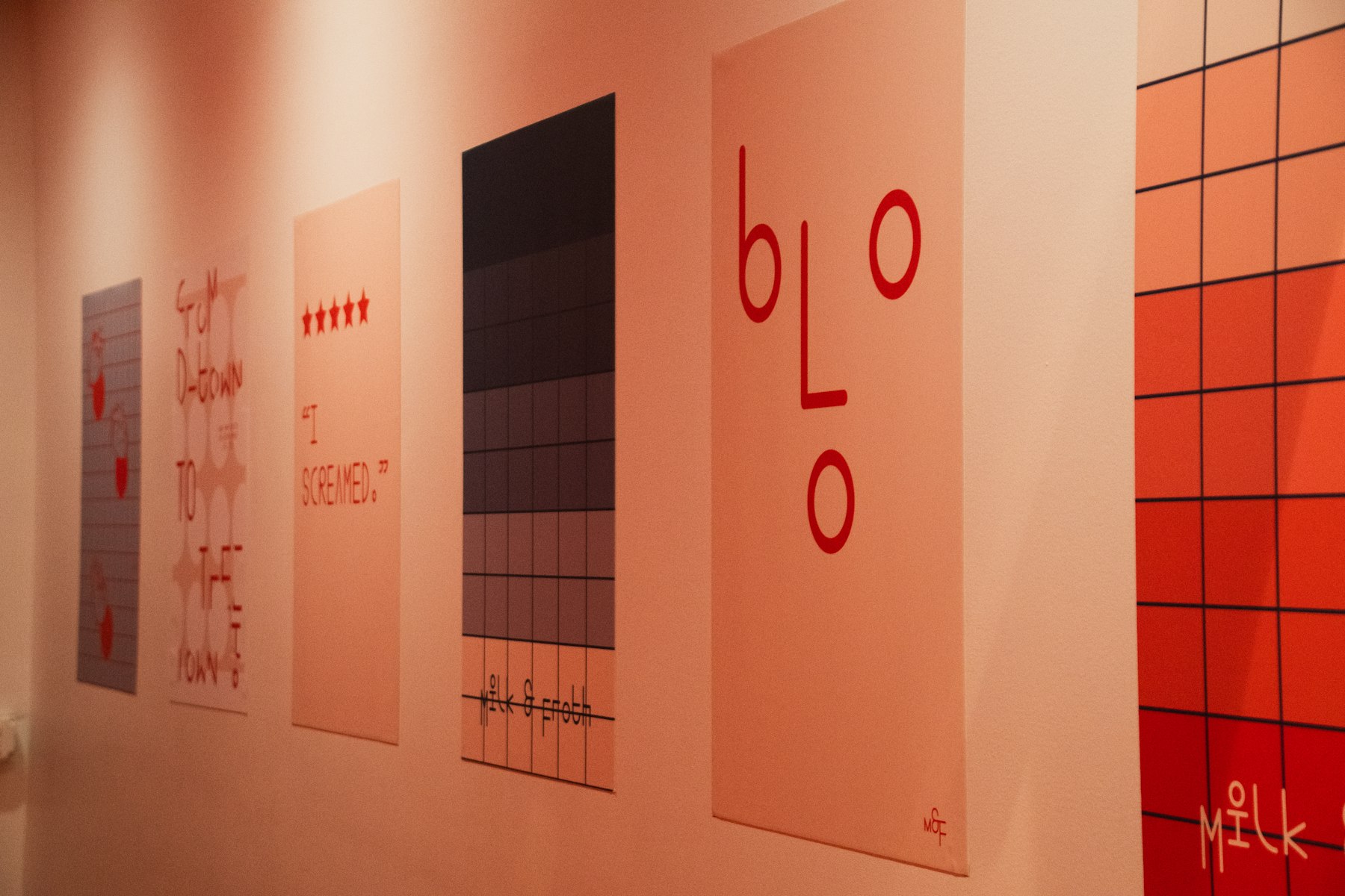 Series of typographic exhibition posters hung along a gallery wall