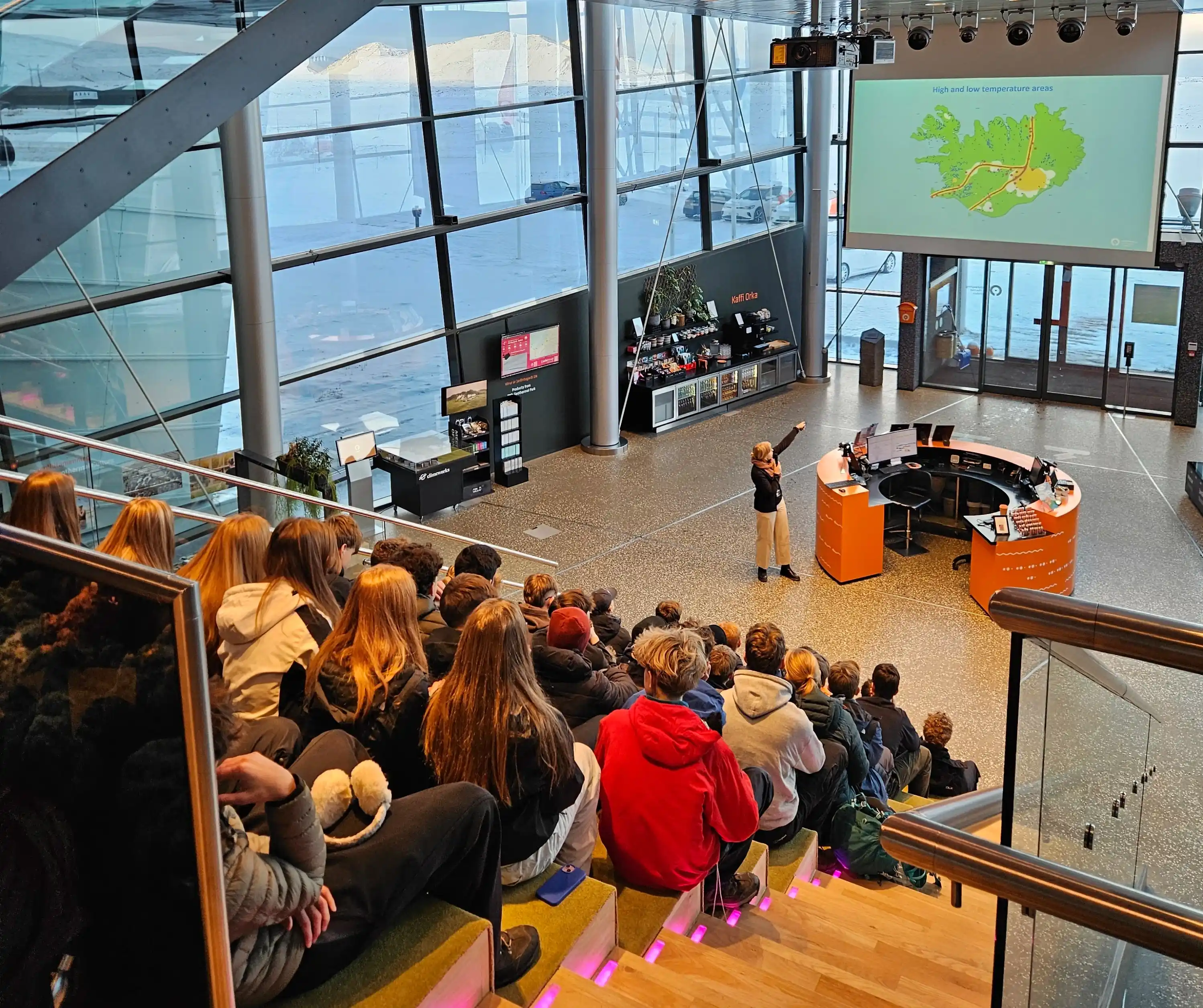 An electric vehicle connected to a home charging station in a leafy residential driveway