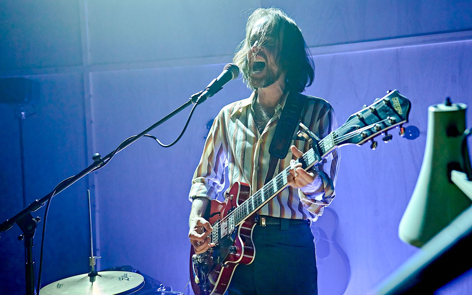 Musician performing on stage with a guitar during Kenrex event.