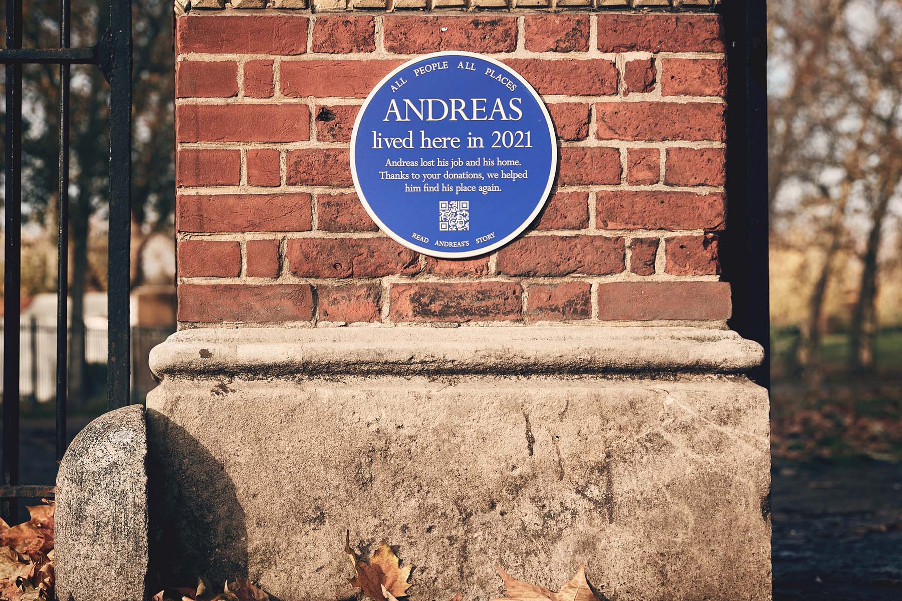 Blue plaque attached to a brick wall that say's Andreas lived here in 2021