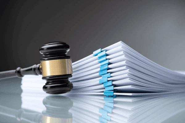 a gavel in front of a stack of papers