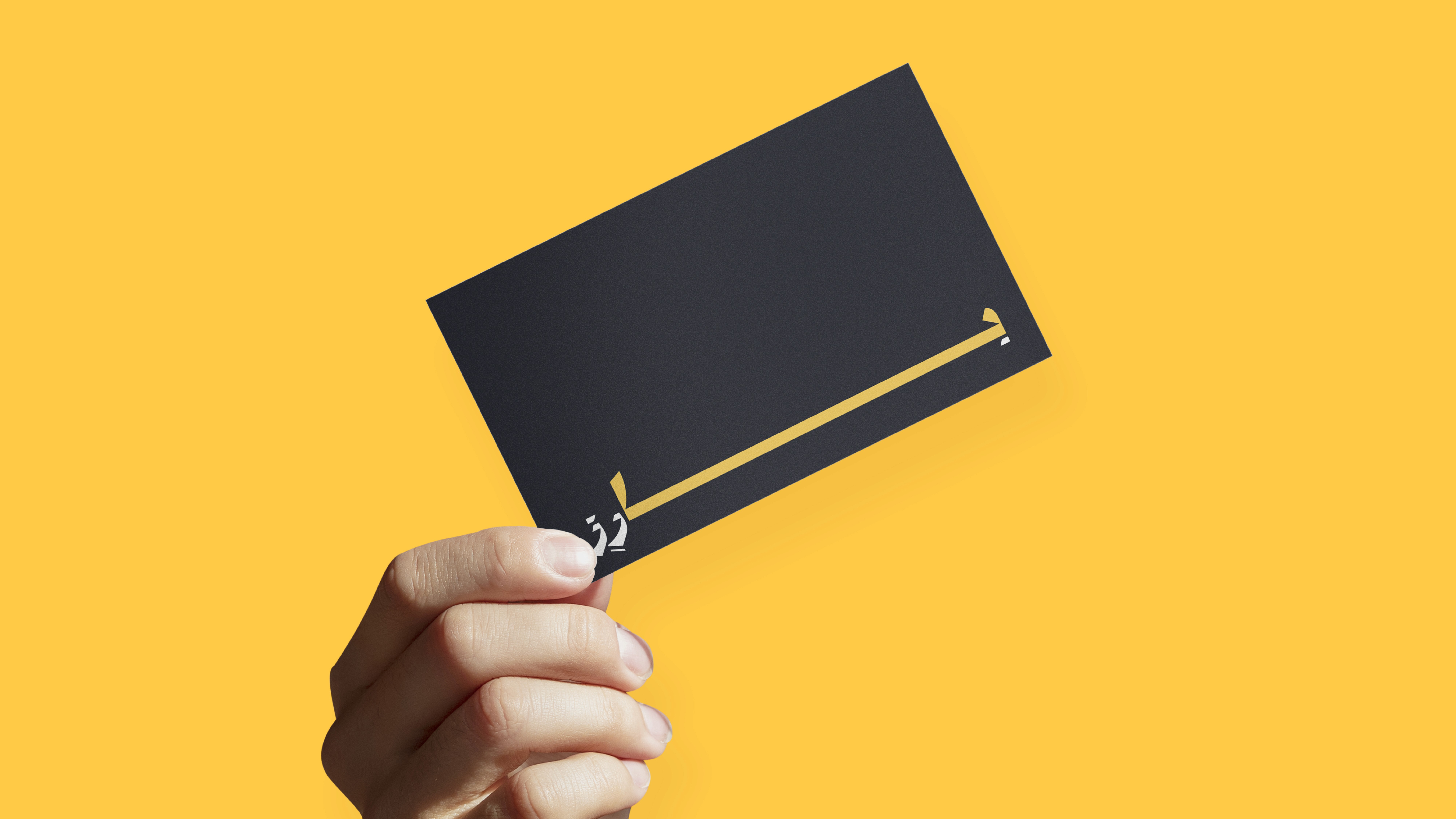 Shiny metallic silver foil pouch lying flat, printed with a large black outline of a smiley face, all set against a bright orange backdrop.