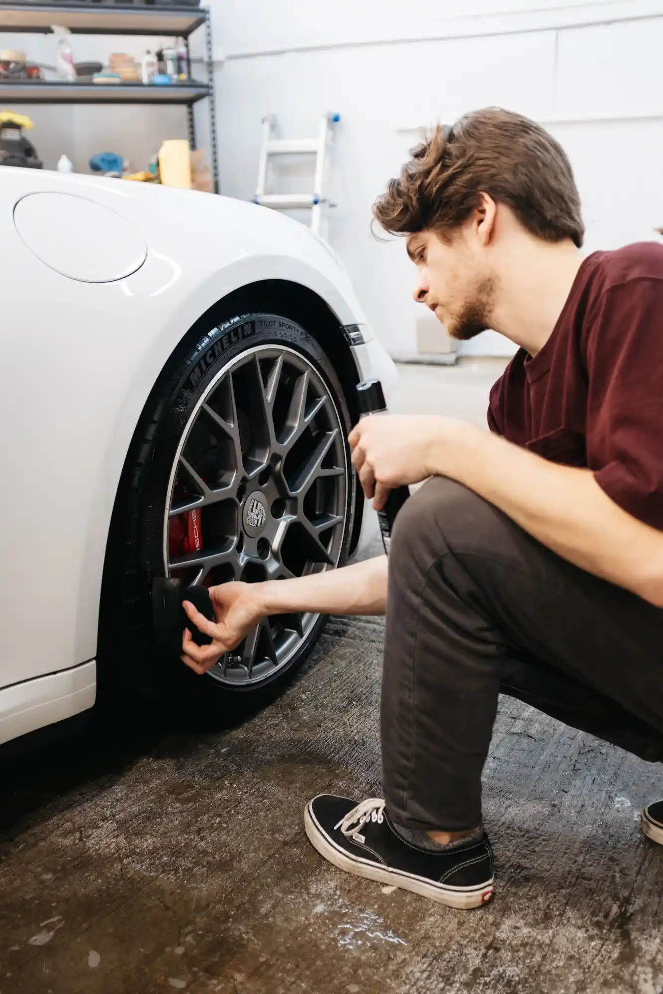 A guy detailing a porsche 911 at a detail shop in kansas city