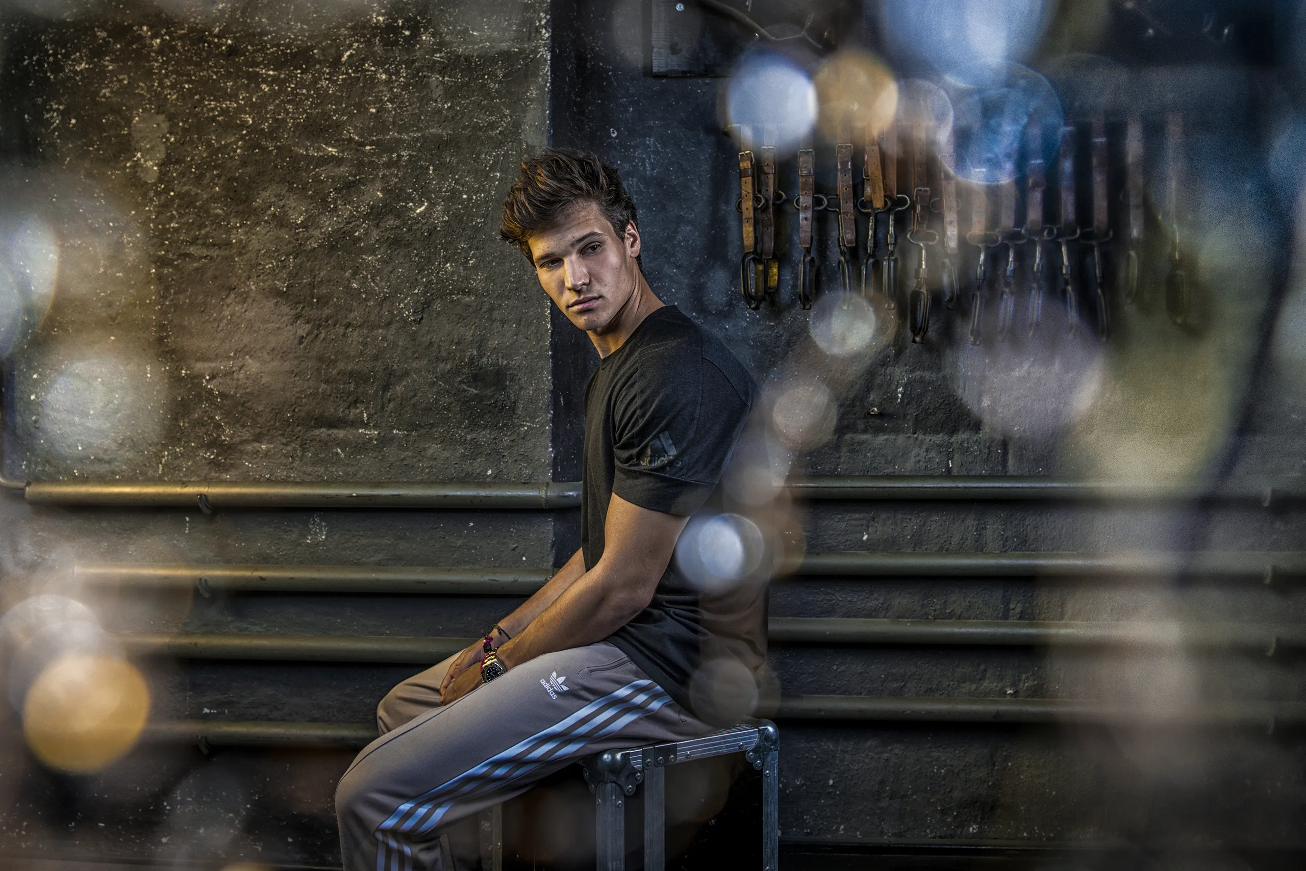 A cinematic portrait of Wincent Weiss sitting on stairs with beautiful light flares.