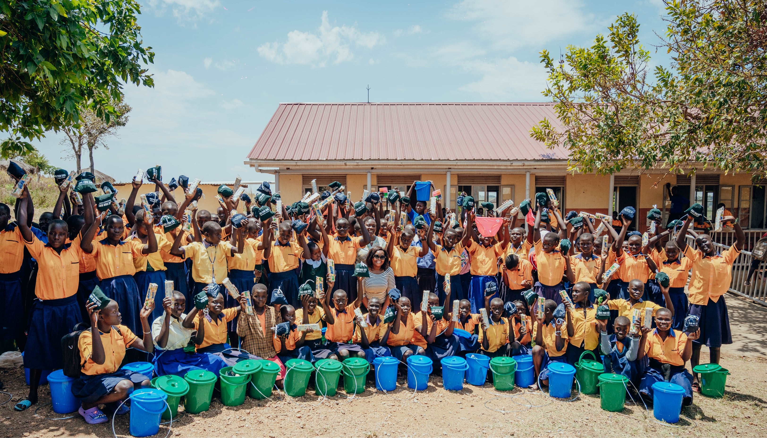 Group picture of students holding SHE FOR SHE reusable pads.
