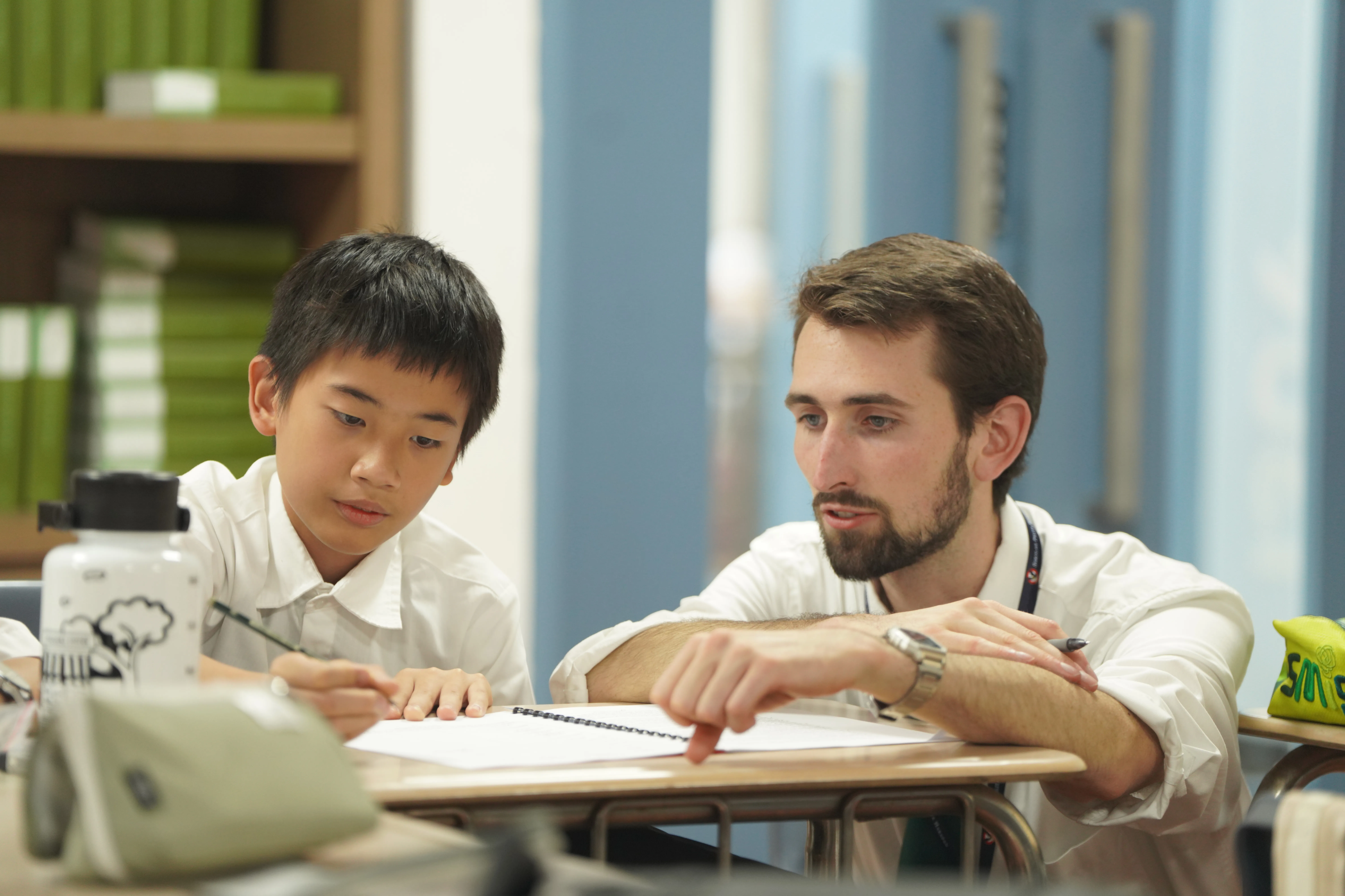 woman carrying white and green textbook