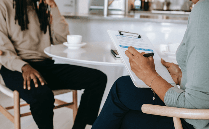 Professional taking notes during consultation with client.