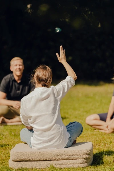 Womain on lair with her hand up, taling to group of peoples