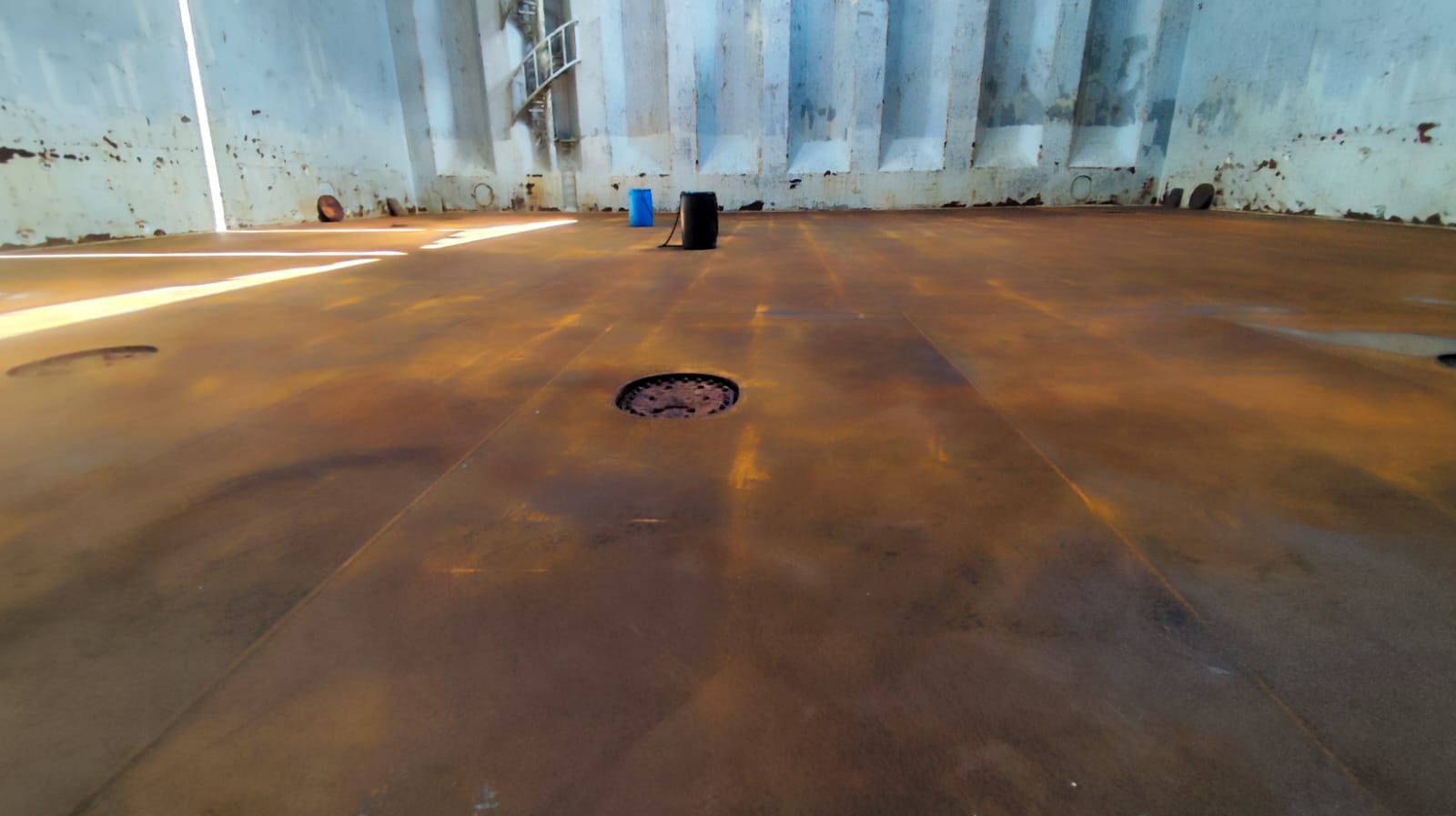 Tank top and lower bulkhead area after cargo hold cleaning, showing cleaned steel surface with remaining staining from coal cargo.