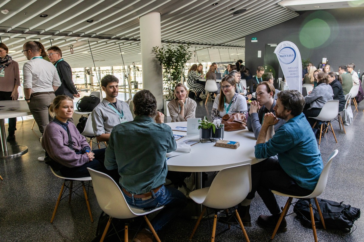 Zwei Geschäftspersonen stehen an einem Konferenztisch und diskutieren intensiv