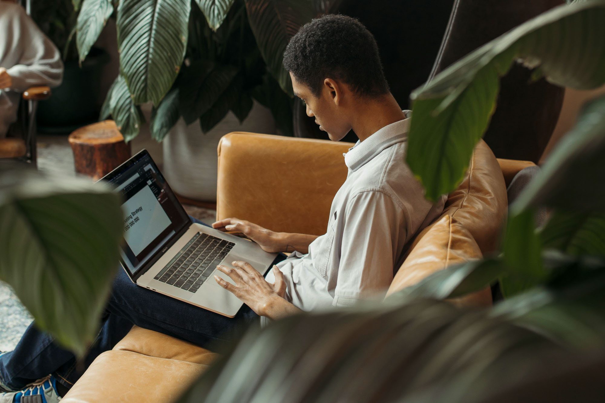 Collaborative work session overhead view of six people collaborating at a rustic wooden table with coffee, papers, and a laptop