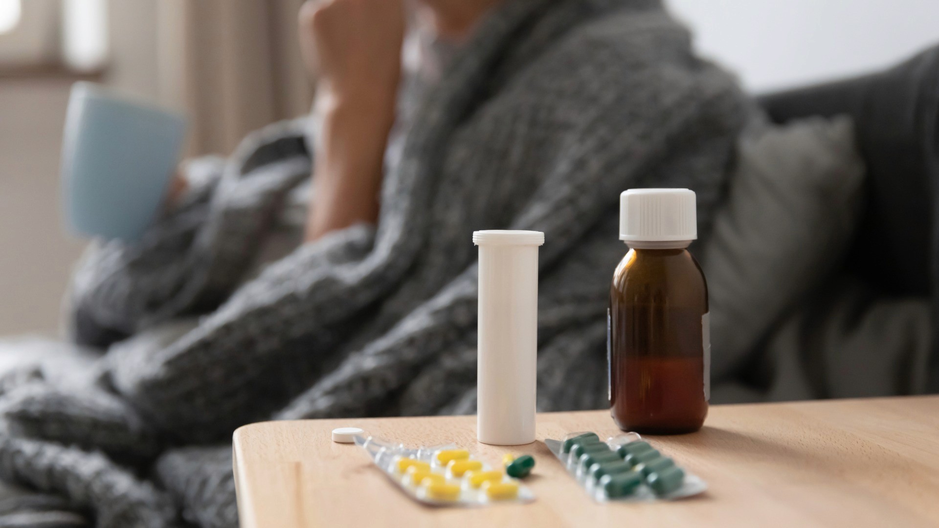 Patient in hospital bed with medicine on the bedside table