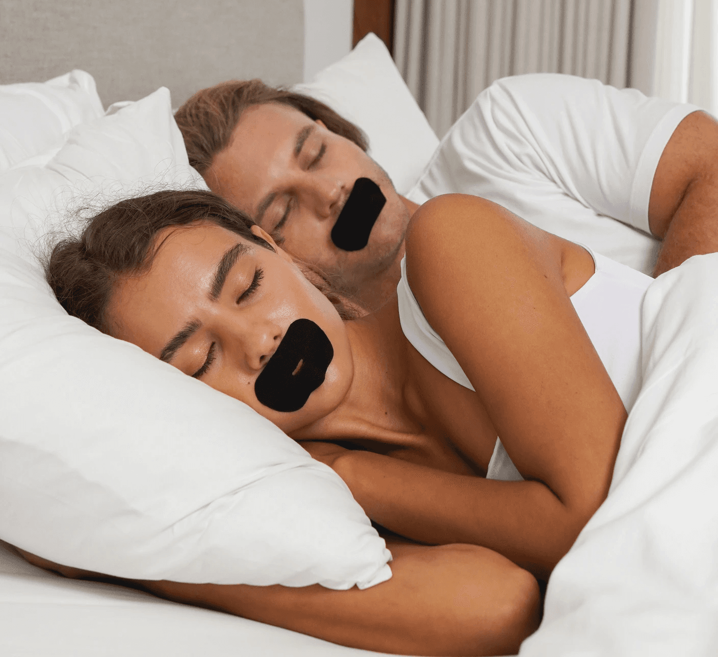 A couple sleeping with SleepSeal premium mouth tape allowing them to sleep deeper