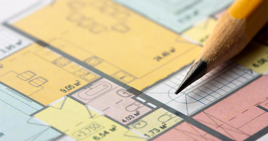 Pencil over a detailed residential floor plan showing room layouts and dimensions.