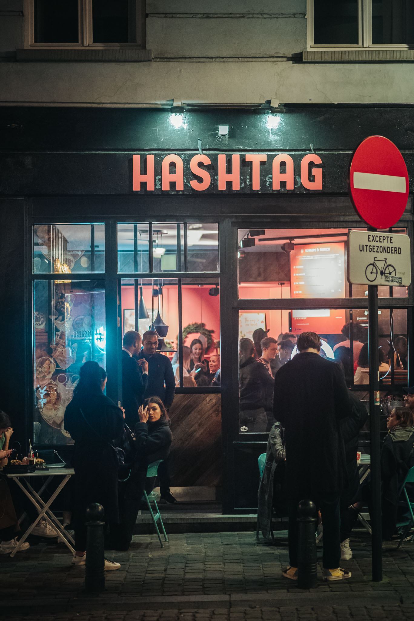 Modern home office setup with a monitor, ergonomic chair, keyboard, and indoor plants near a window with blinds.