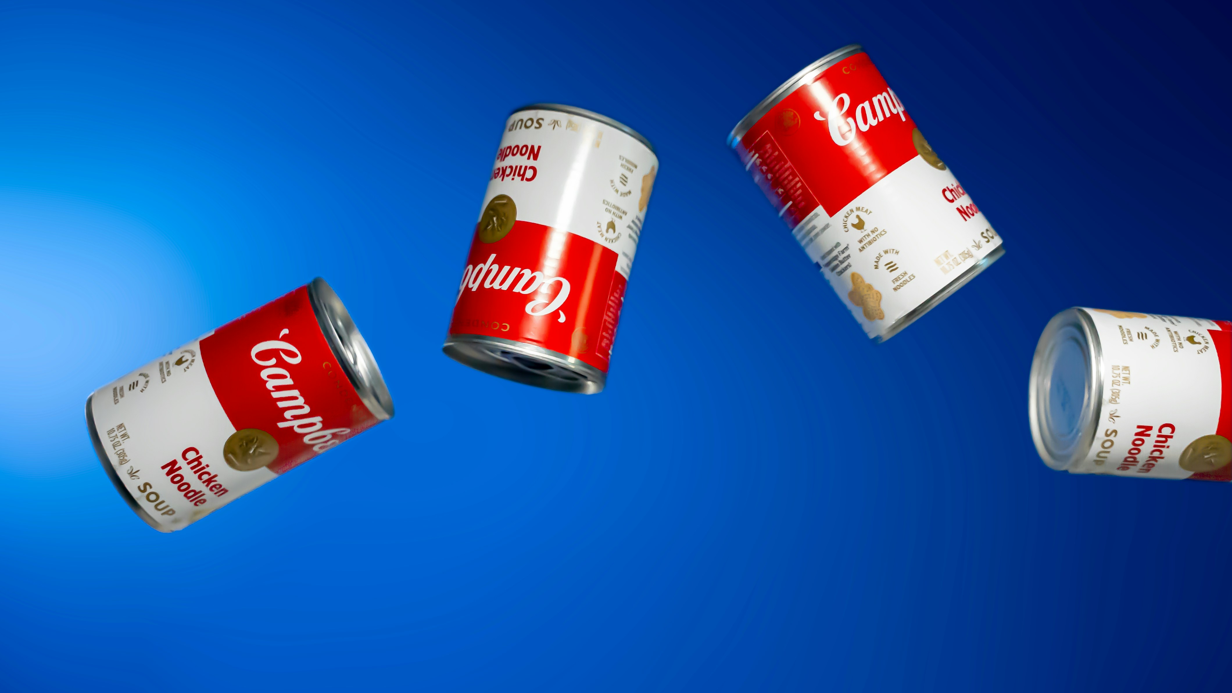 three cans of campbell's beer flying through the air