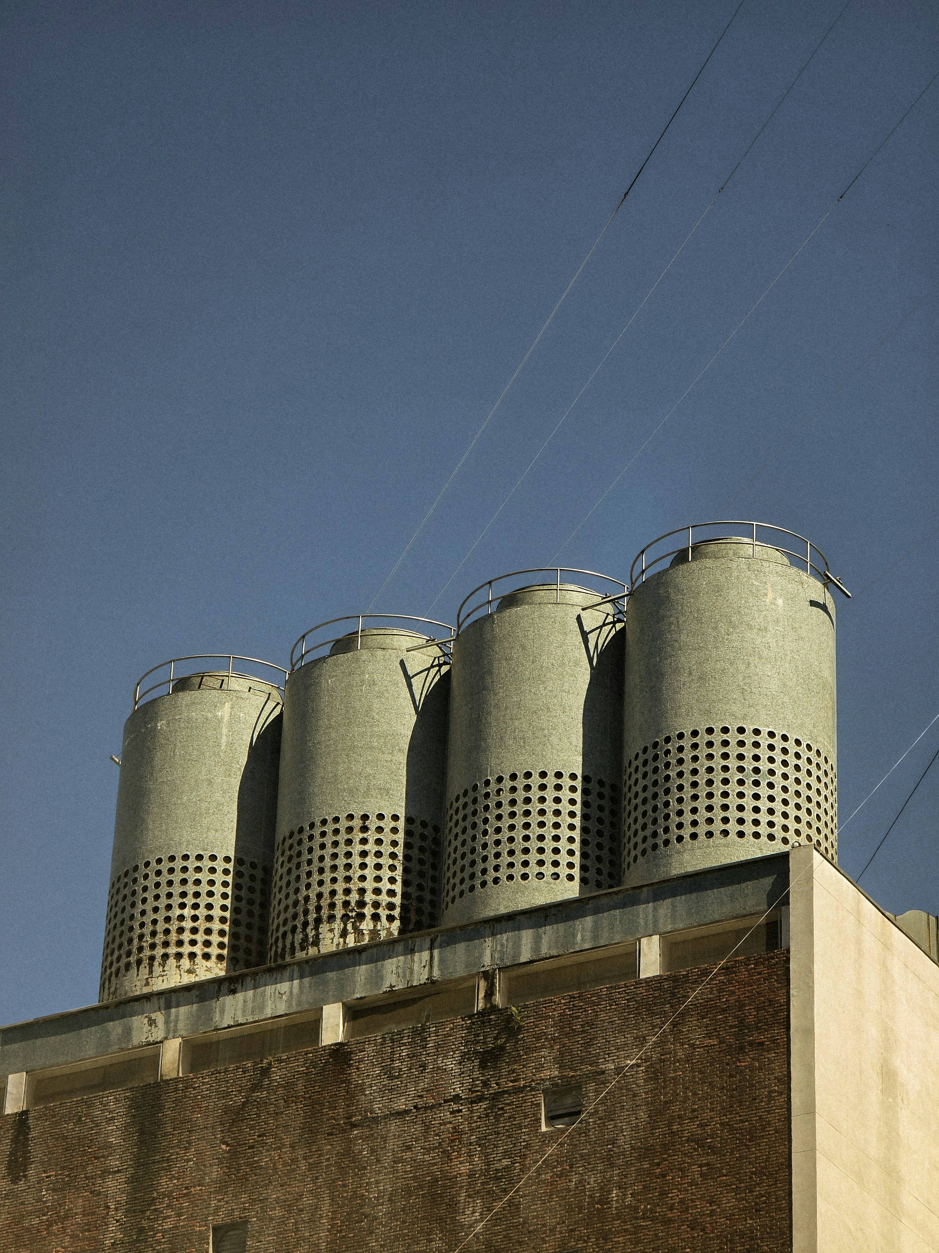 A tall building with four silos on top of it