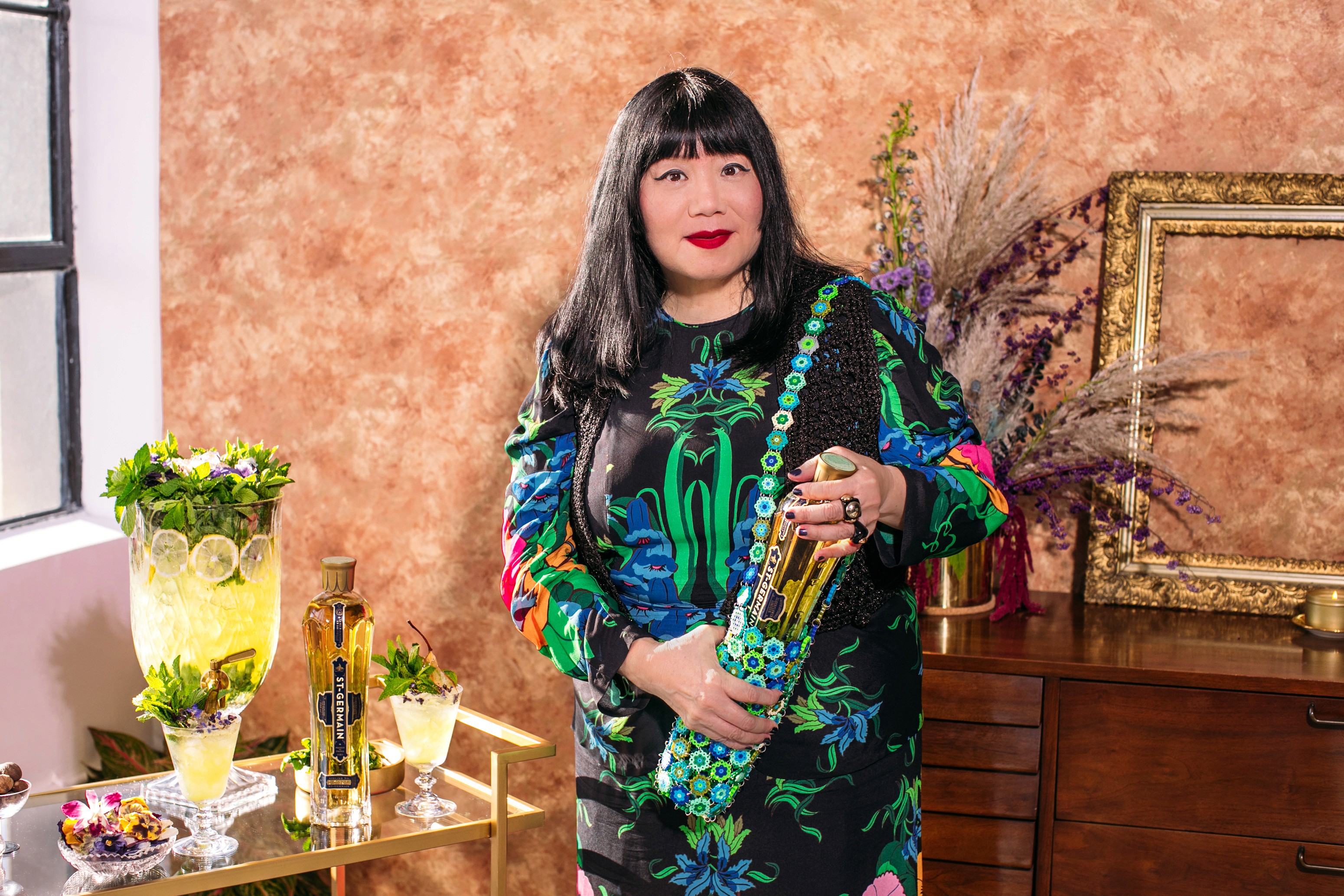 Anna Sui portrait beside a St-Germain holiday cocktail display