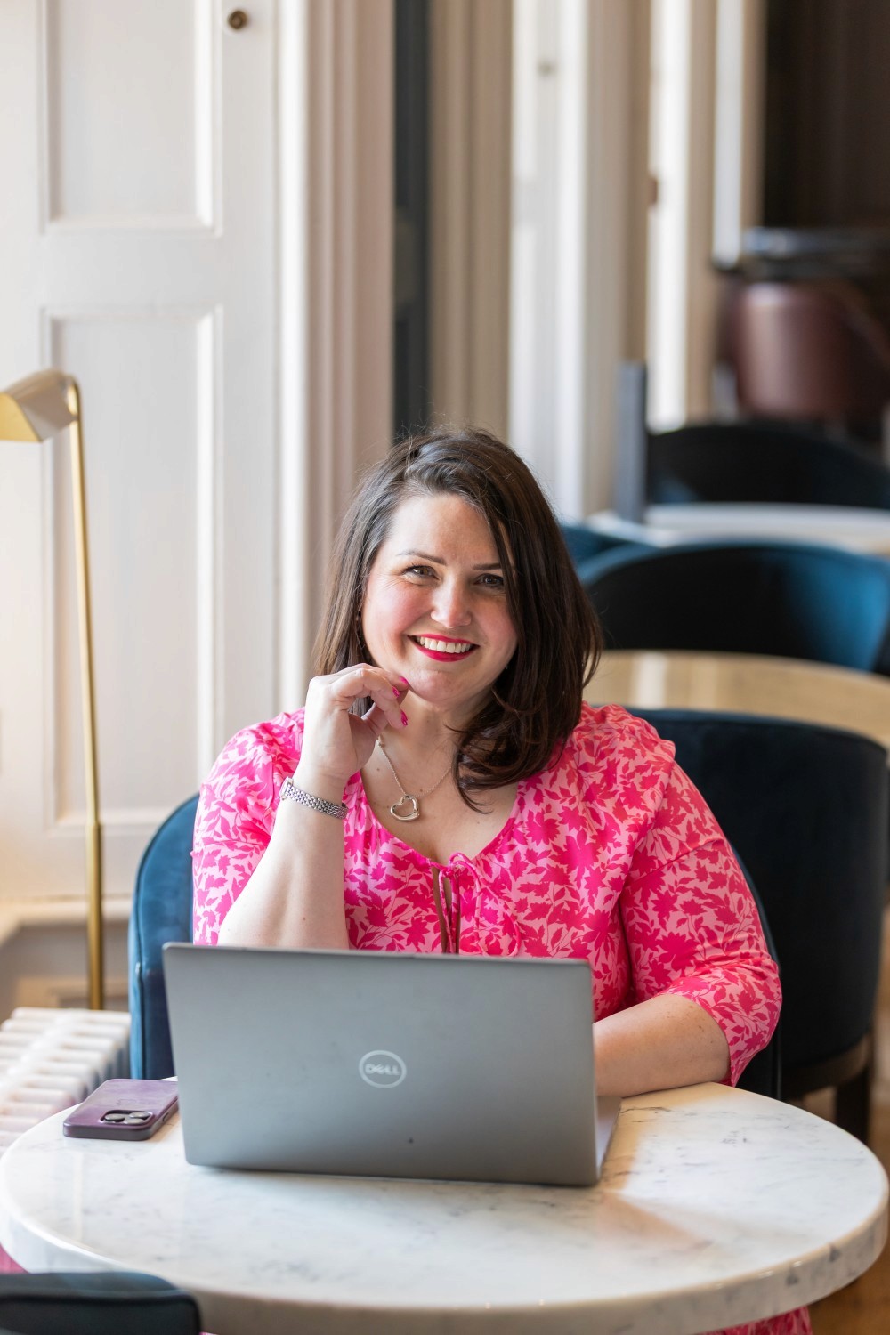 Various houseplants displayed on white shelves.