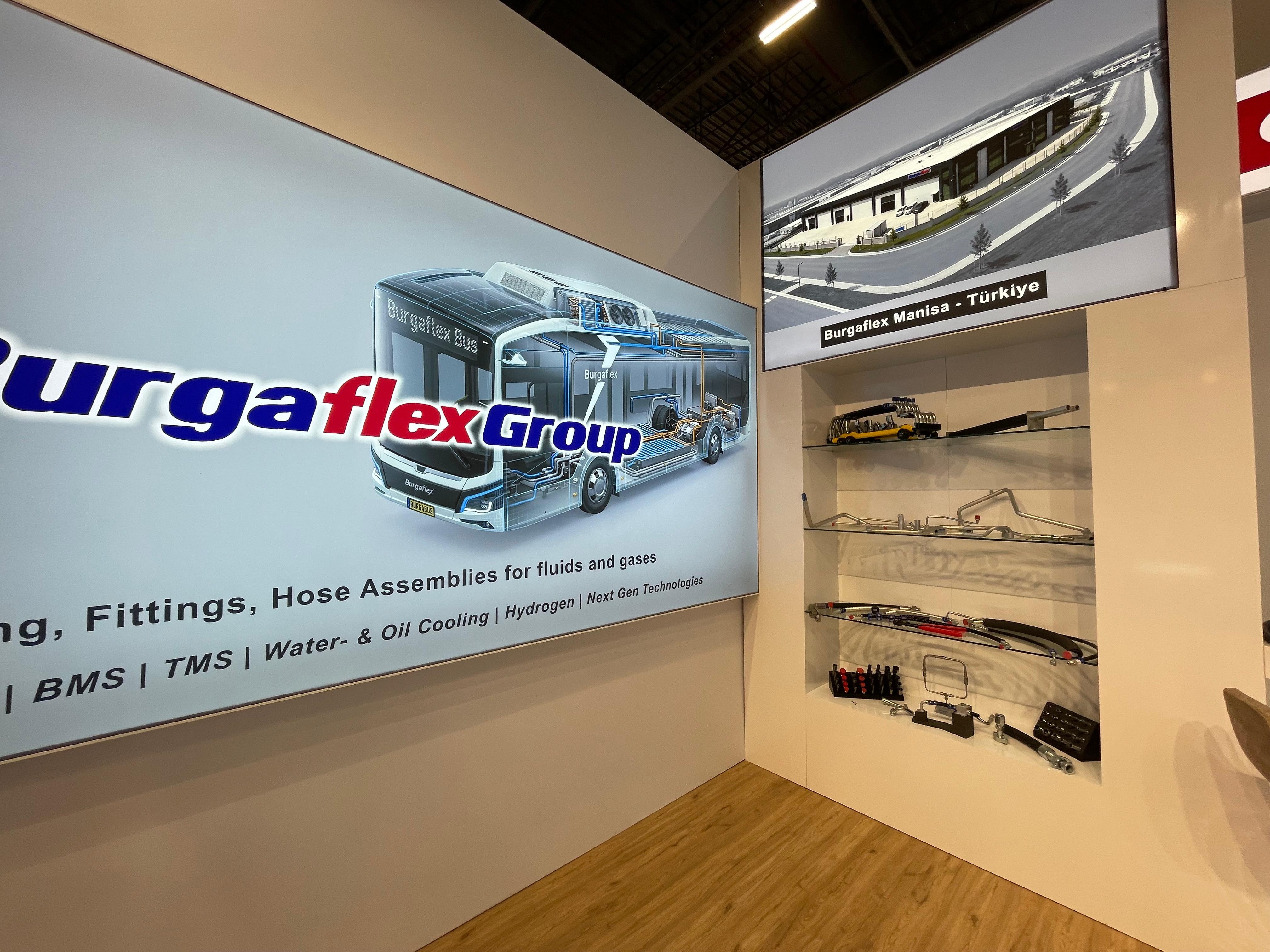 Glass display shelves and large product graphics at the Burgaflex stand, showcasing tubing, fittings, and hose assemblies.