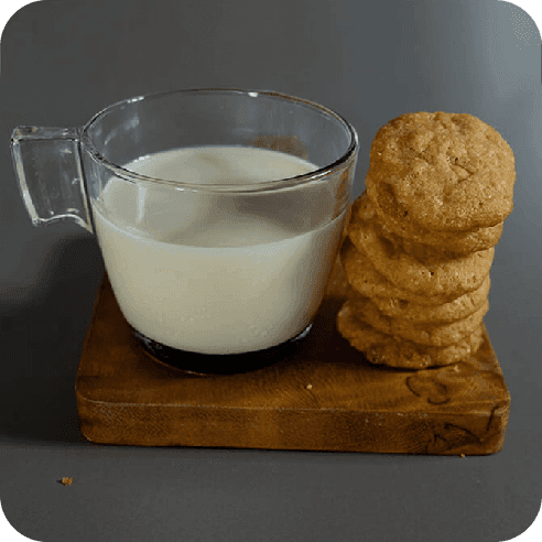Galletas artesanales de masa madre acompañadas de un vaso de leche, presentadas sobre una tabla rústica.