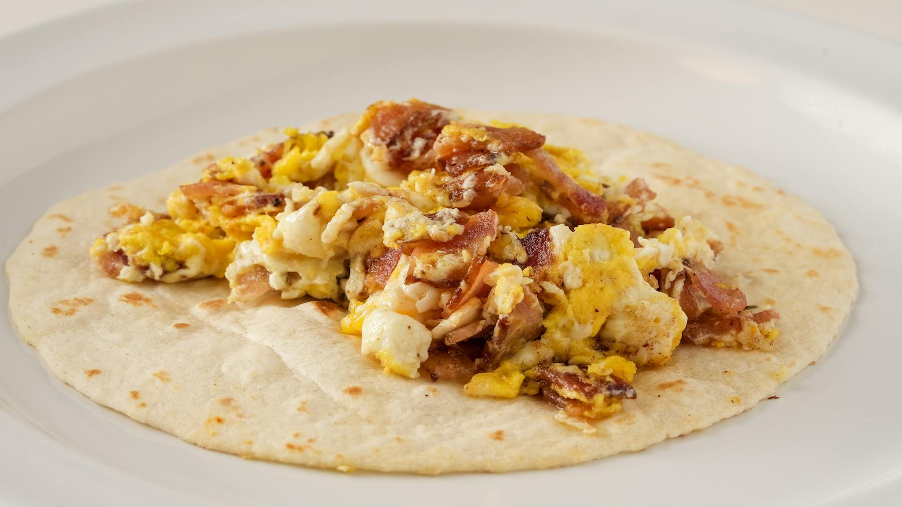 BACON TACO Crispy bacon paired with soft, scrambled eggs for a classic