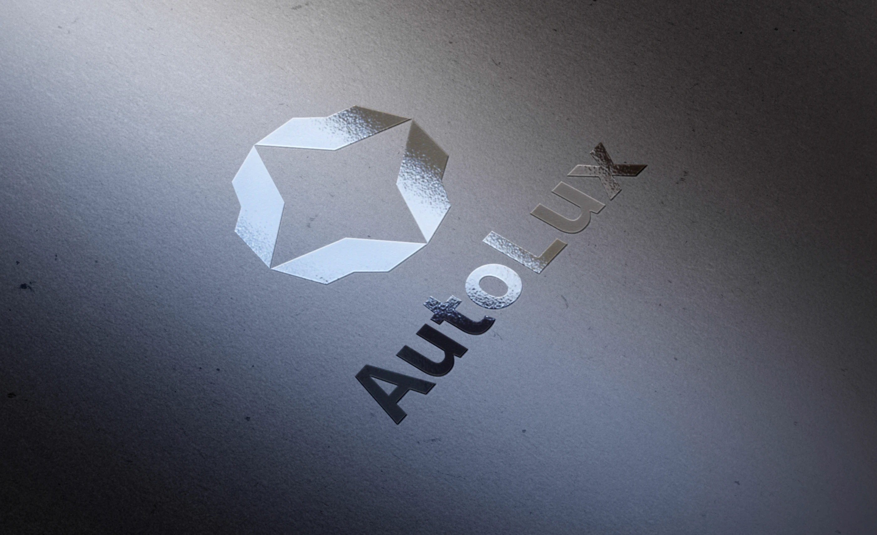Logo et emblème AutoLux avec effet argenté texturé. Création de charte graphique et direction artistique pour marque automobile premium.