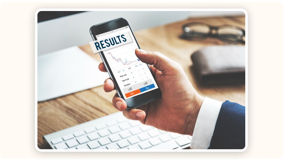 Main tenant un smartphone affichant des graphiques de résultats et de performance marketing