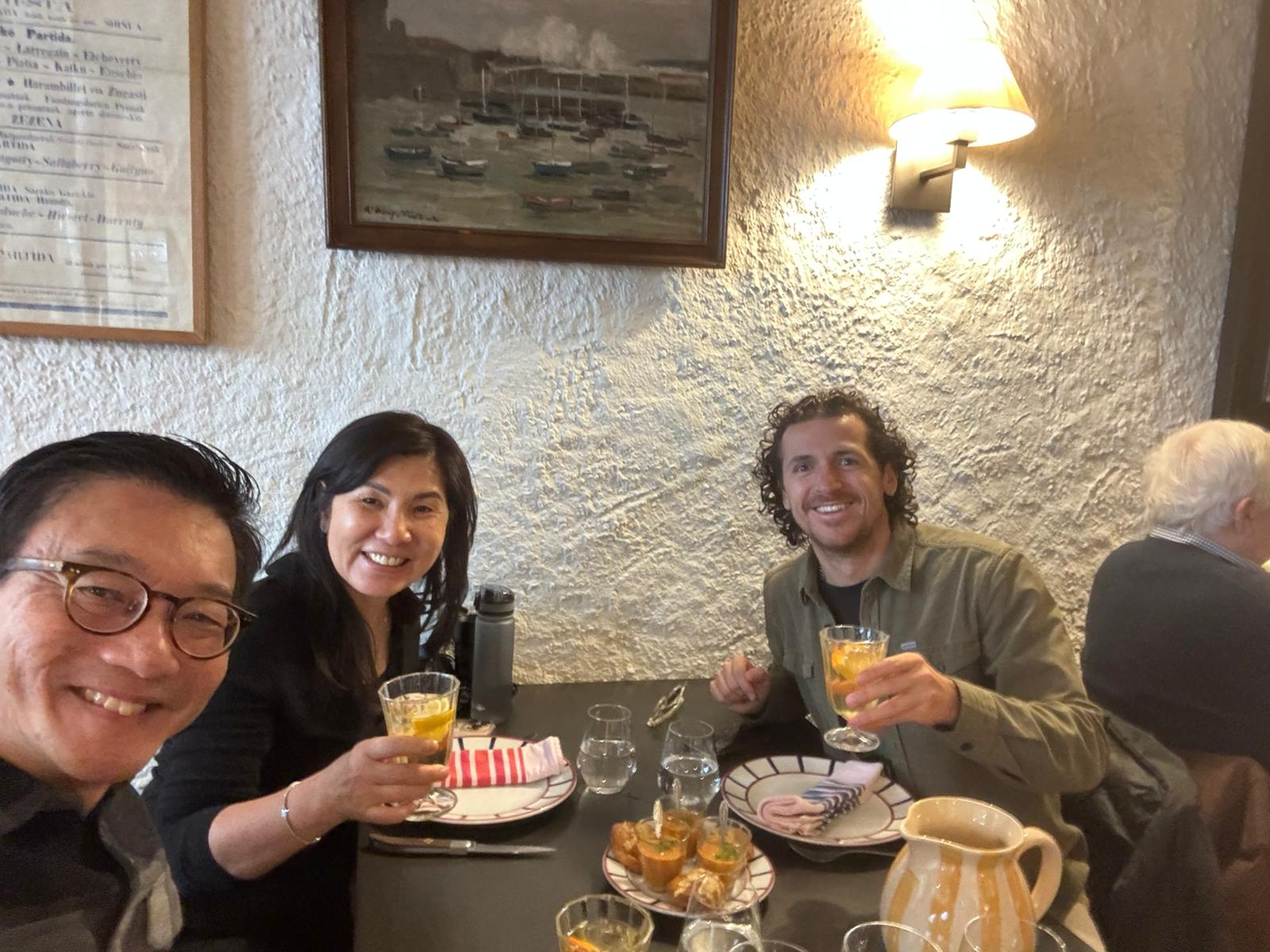 Scenic view of the rugged Basque cliffs and local surfers riding waves at Parlementia break in Guéthary during a guided coastal tour.