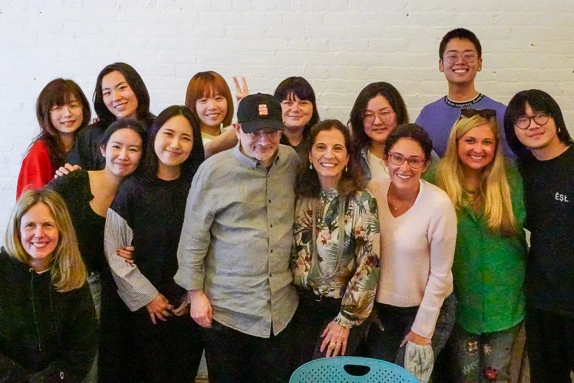 A photo of a group of students and teachers standing in a room.