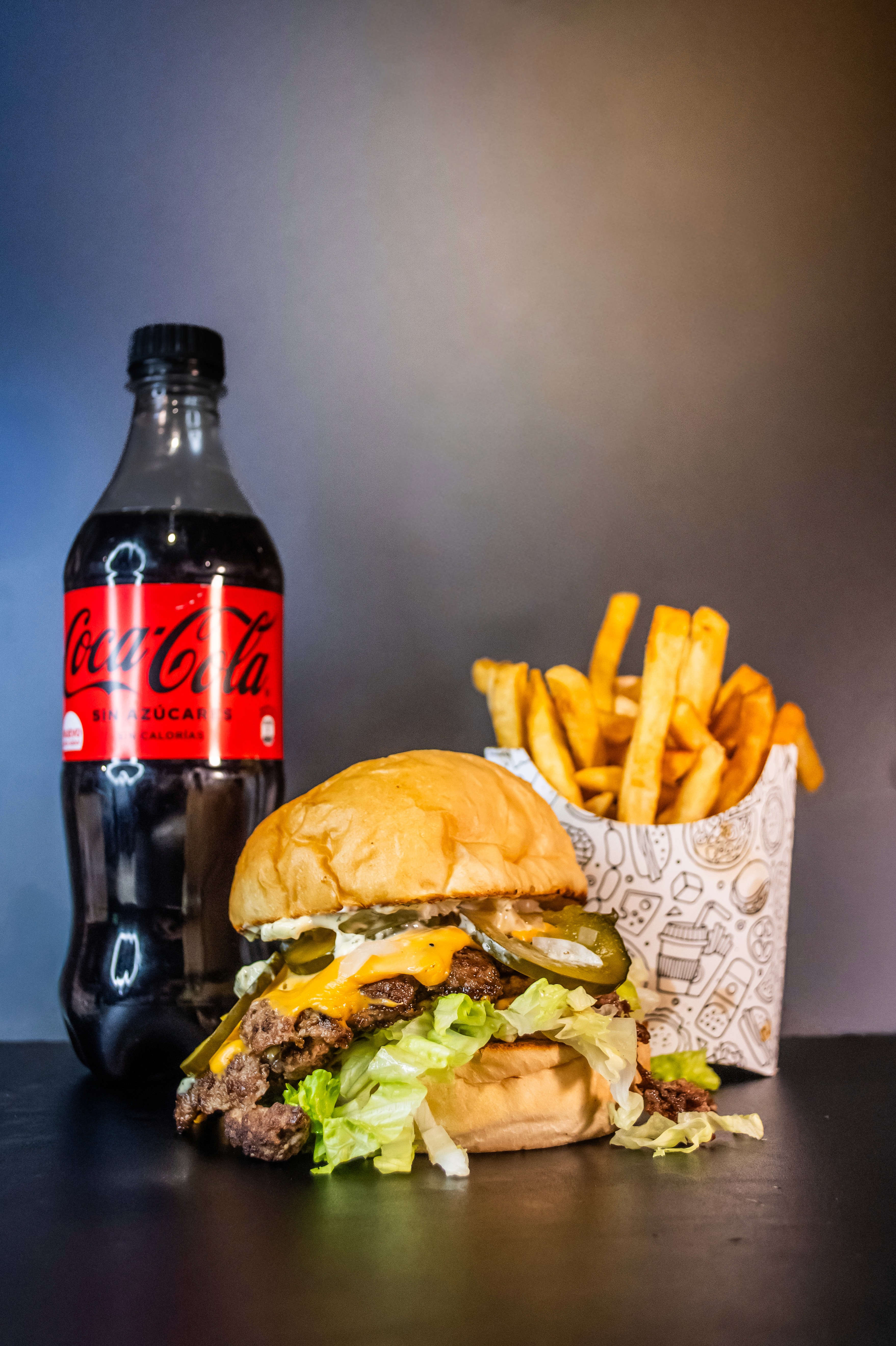 hamburguesa smash con papas fritas y refreso coca cola.