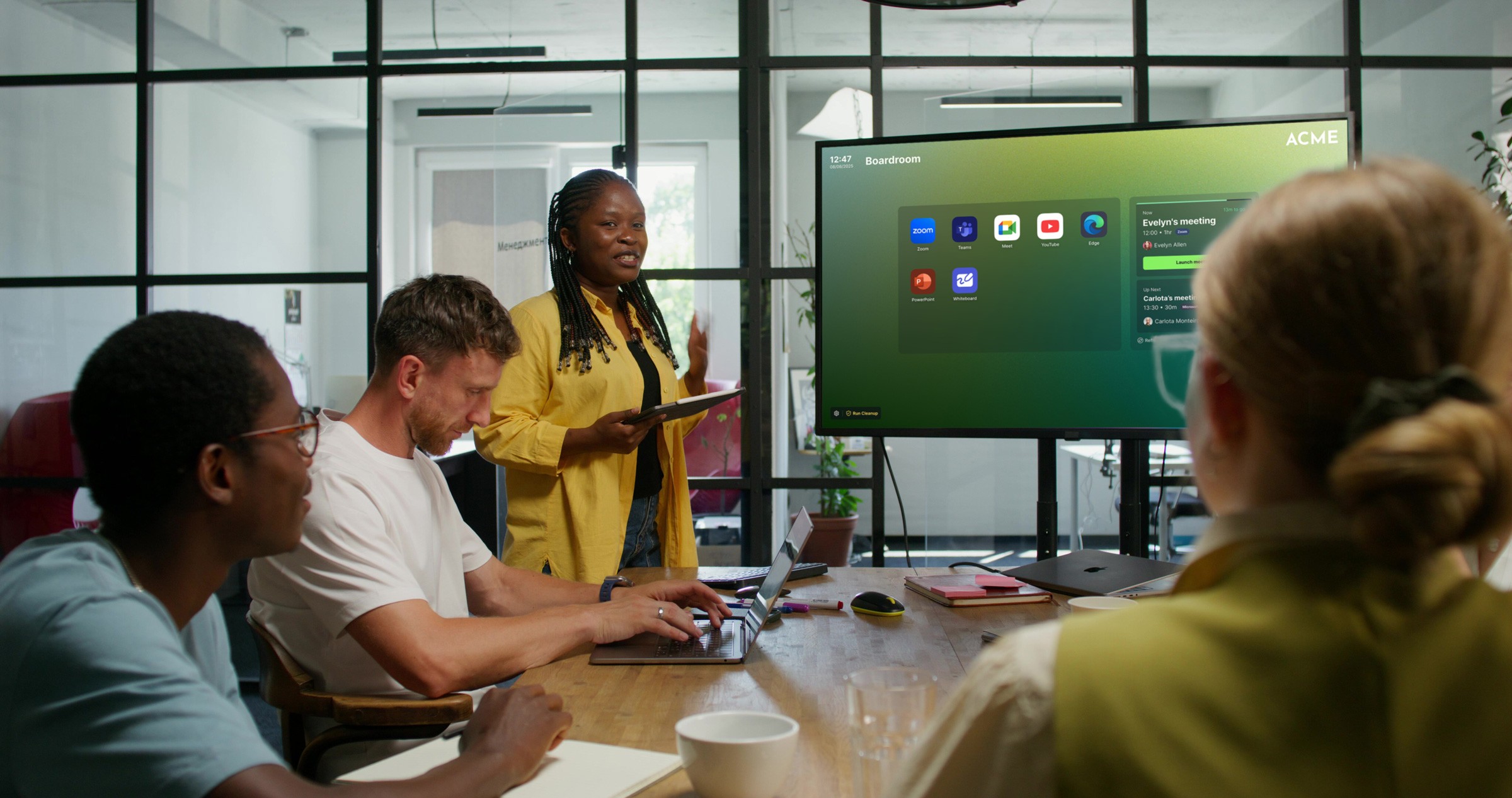 A champion of the call and app launching solution showing others in a meeting room how best to use the application