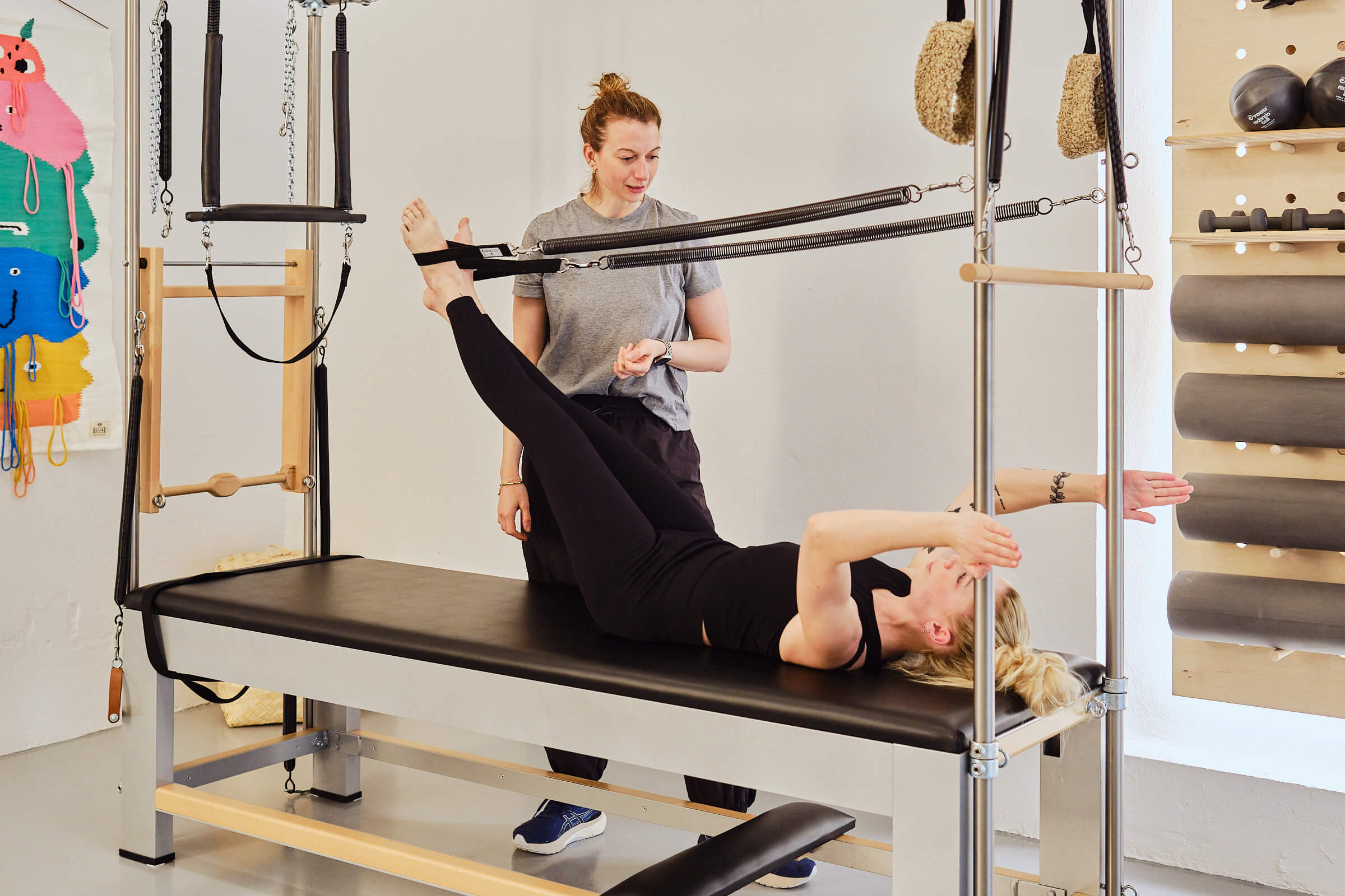 Kvinder bliver guidet igennem øvelse på cadillac af pilatesinstruktør