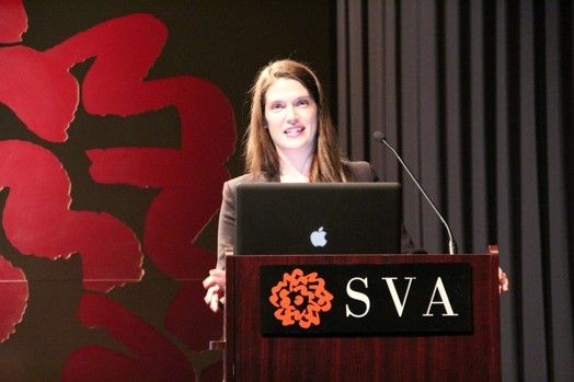 a woman giving a speech from a stand in the "designer as" thesis presentation