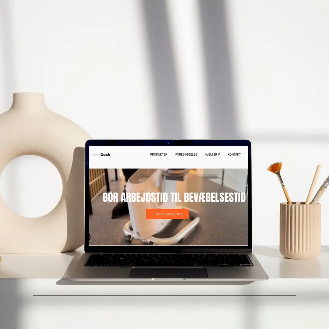 Computer der viser hævesænke bord med cykel, omgivet af vaser.