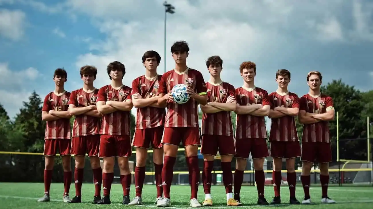 A team of football players in red are standing on the pitch of the tournament they are participating. Their coach found the tournament with help of the CoachingArea tournament finder.