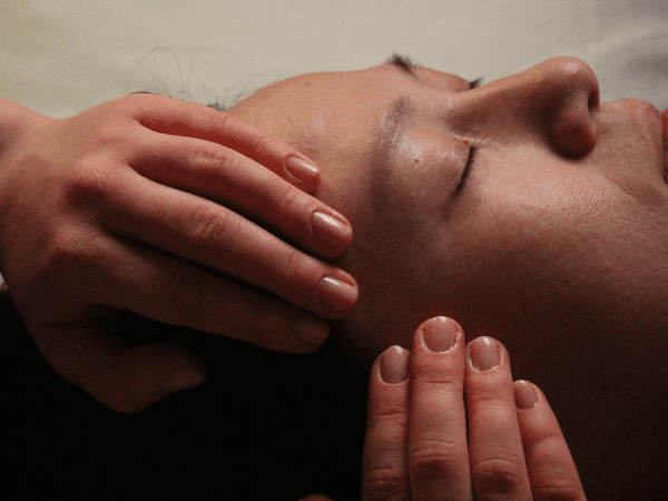 acupuncturists assessing a patient's face for inserting facial acupuncture needles