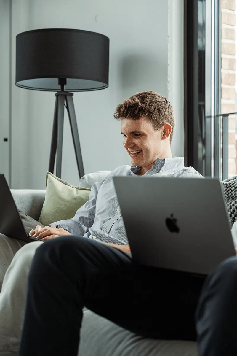 Confident man with short brown hair and beard, wearing a navy zip-up in natural light