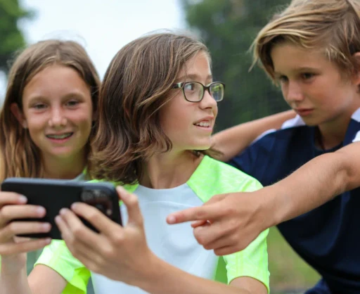 Group of young soccer players reviewing game footage together on a smartphone, showcasing the interactive features of Reeplayer’s mobile app
