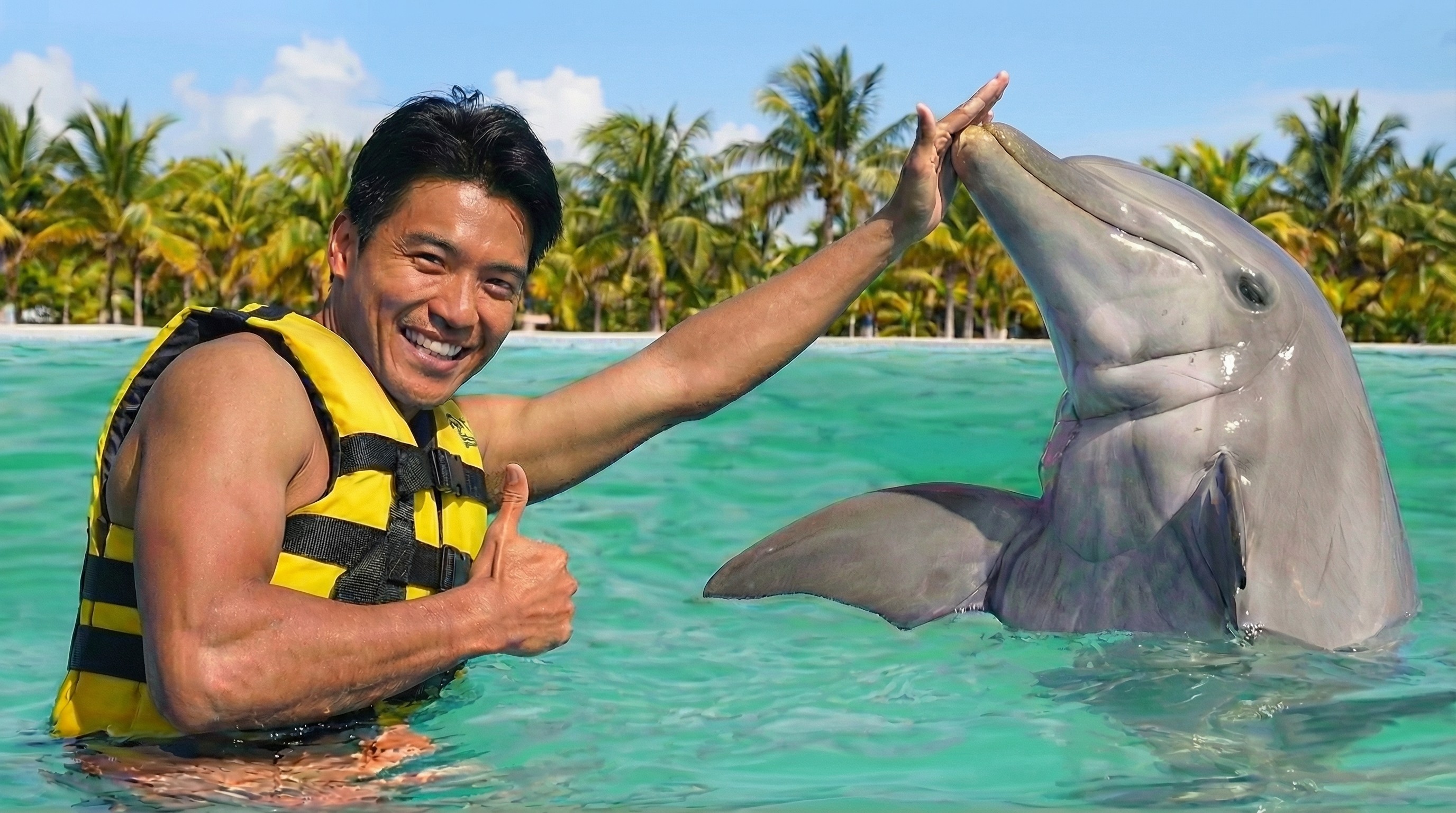 Smiling man high-fives a dolphin.
