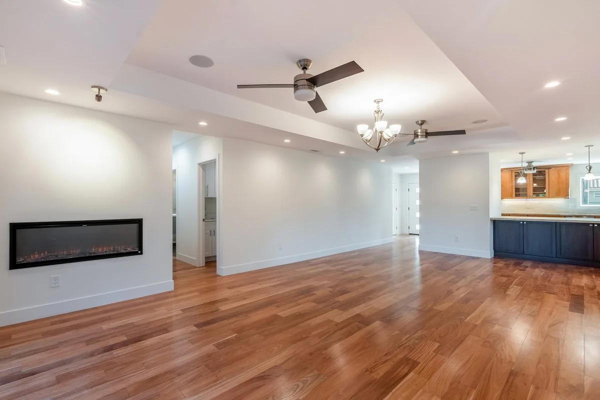 A bright living room with wood floors and a wall fireplace in the Cupertino project