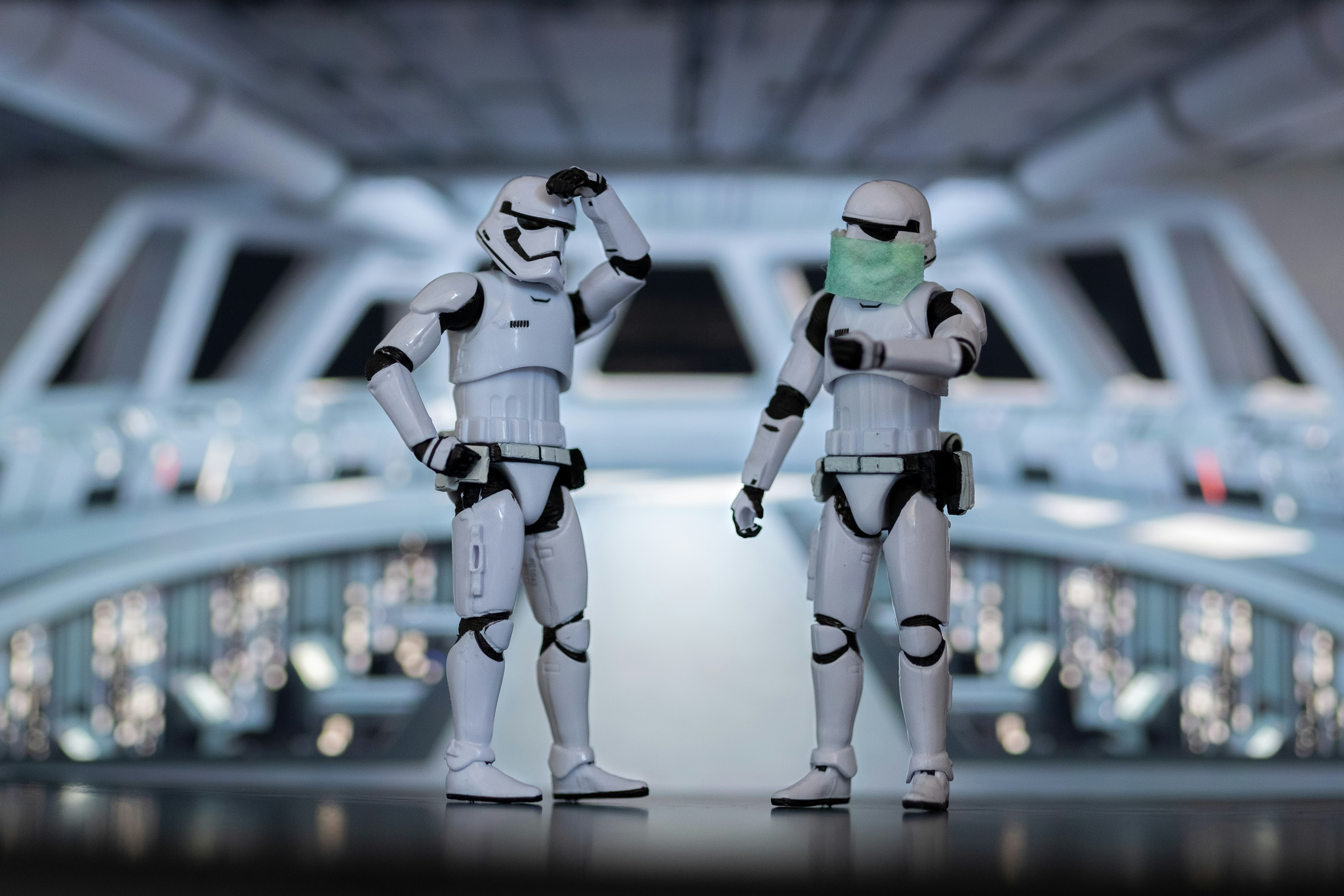 two stormtrooper figurine toys in comical confused poses on the bridge of a starship