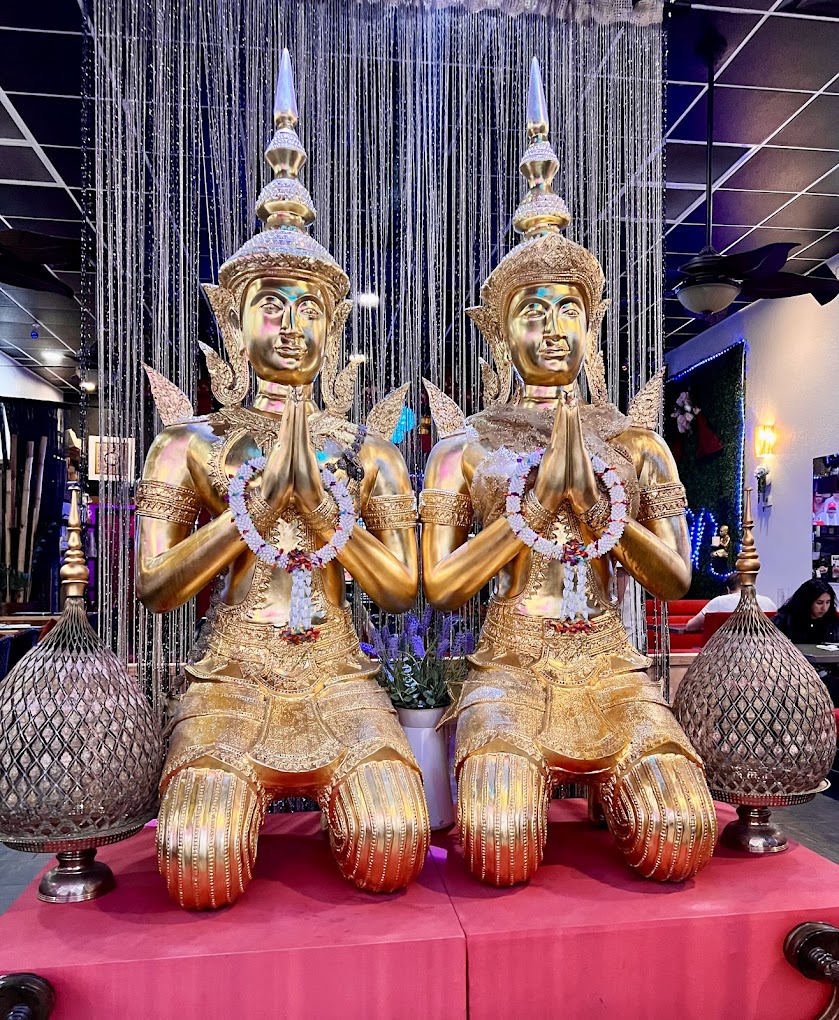 Two buddah statues kneeling in prayer