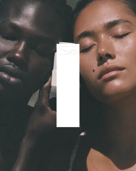 A photo of two persons with a white band with the Scene Studios' logo on top.