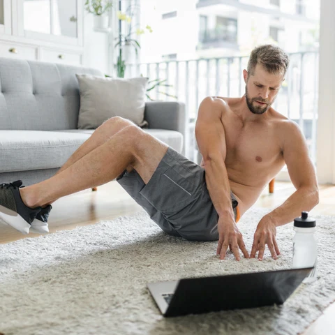 woman wearing black sport brassiere standing beside gray rock