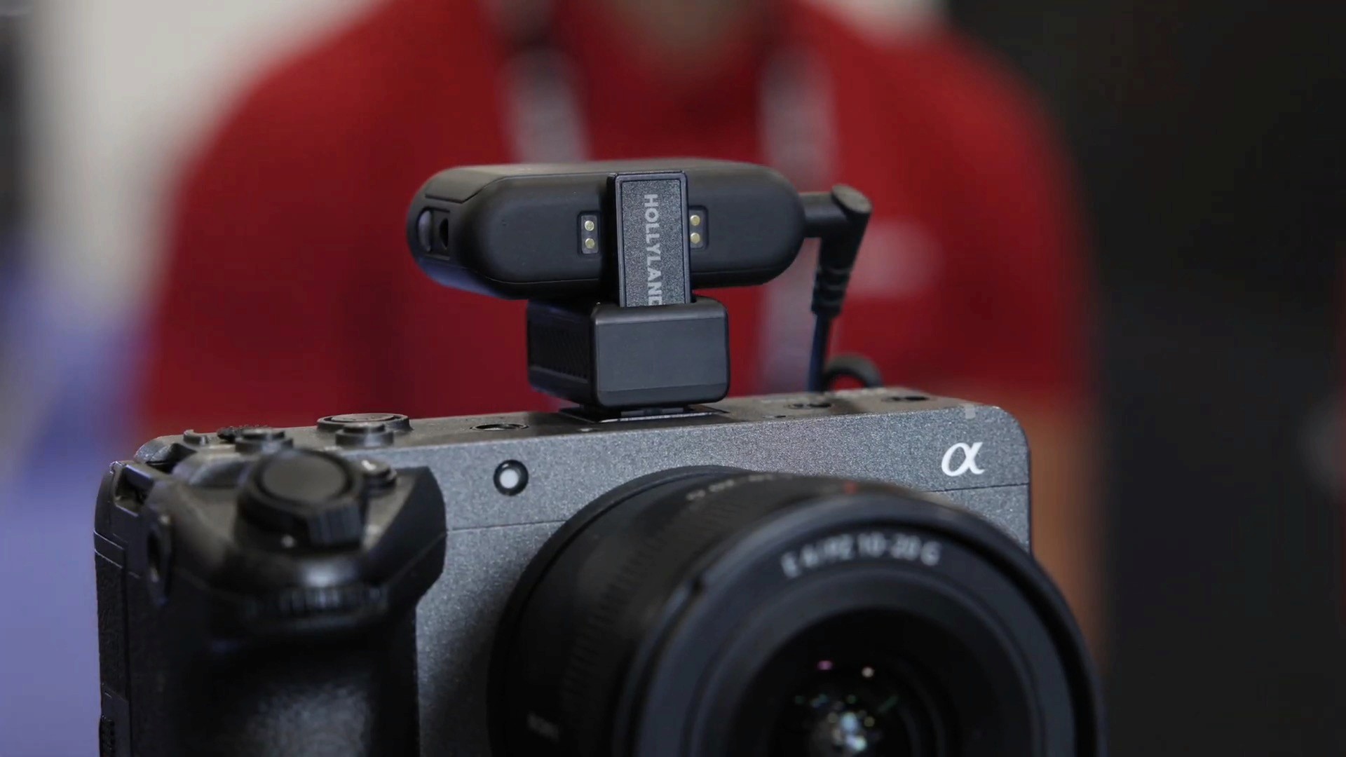 A Hollyland wireless microphone receiver module mounted on top of a Sony Alpha mirrorless camera.