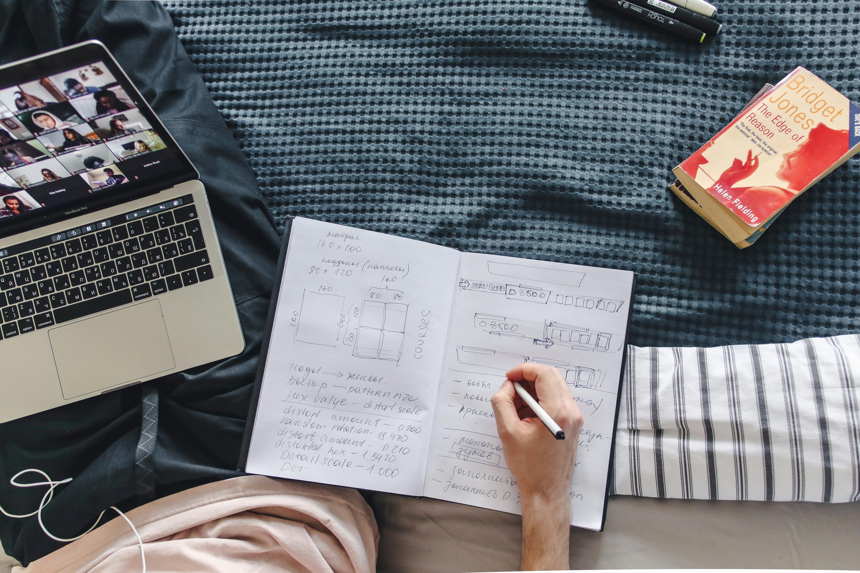 Studente prende appunti con laptop e schemi: studio a distanza e preparazione esami