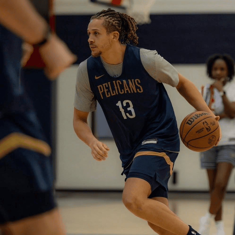 Josh Oduro in a Pelicans practice jersey dribbling the ball.
